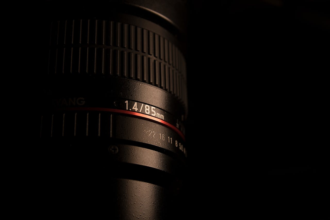 Detailed close-up of an 85mm camera lens showcasing aperture settings with a dark, moody tone.